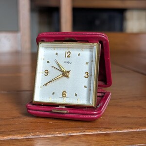 ImHof Swiss Vintage folding travel alarm clock in red leather case, mechanical wind-up movement, collectible mid-century Swiss timepiece