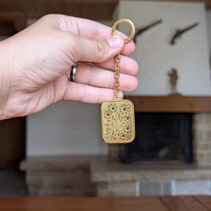 Reuge Sainte Croix Schweizer Vintage-Gold-Spieluhren-Schlüsselanhänger mit Blumengravur und Aufziehmechanismus aus der Schweiz