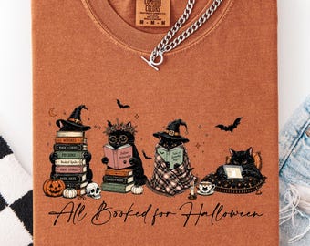 Camiseta "All Booked For Halloween Comfort Colors" con un lindo gato negro y un estilo espeluznante, ideal para amantes de los libros. Camiseta gráfica para bibliotecarias y maestras. Regalo perfecto para ella.
