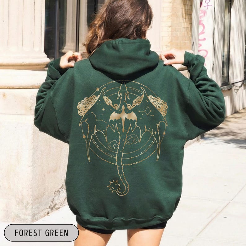 May include: Forest green hoodie with a gold dragon design on the back. The dragon is surrounded by a circular pattern with stars and clouds. The hoodie has a hood and long sleeves. The text "FOREST GREEN" is at the bottom.