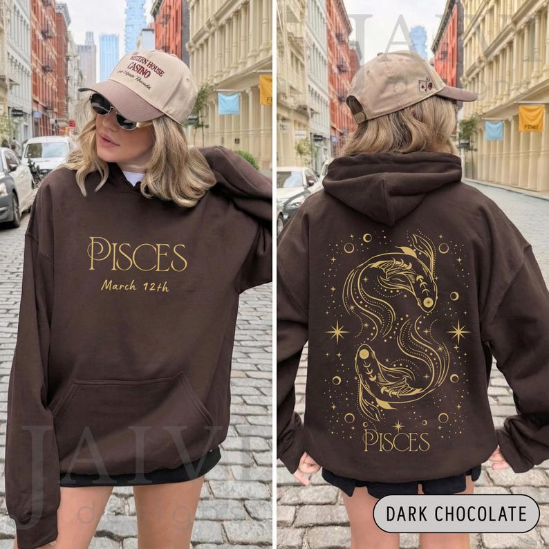 K&ouml;nnte beinhalten: Ein dunkelbrauner Kapuzenpullover mit einer Vordertasche und Kapuze. Auf der Vorderseite steht das Wort "PISCES" in goldener Schrift mit "March 12th" darunter. Auf der R&uuml;ckseite befindet sich ein goldenes Fische-Sternzeichen-Design mit Sternen.