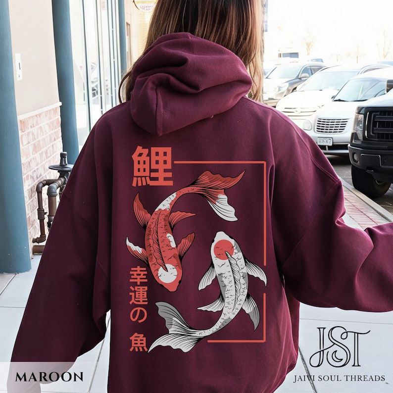 May include: Maroon hoodie featuring a Japanese koi fish design. The back of the hoodie displays two koi fish in red and white, with Japanese characters and a rectangular frame. The word "MAROON" is at the bottom left.
