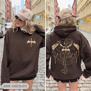 May include: Dark chocolate brown hoodie with a gold dragon graphic on the front and back. The front features a small dragon design, while the back showcases a larger, detailed dragon illustration with celestial elements. The text "DARK CHOCOLATE" is at the bottom.