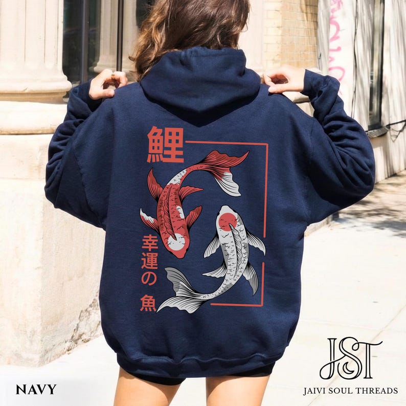 May include: Navy blue hoodie featuring a red and white koi fish design within a red rectangular frame. Japanese characters are above and to the side of the fish. The hoodie has a drawstring hood and long sleeves. The text "NAVY" is at the bottom.