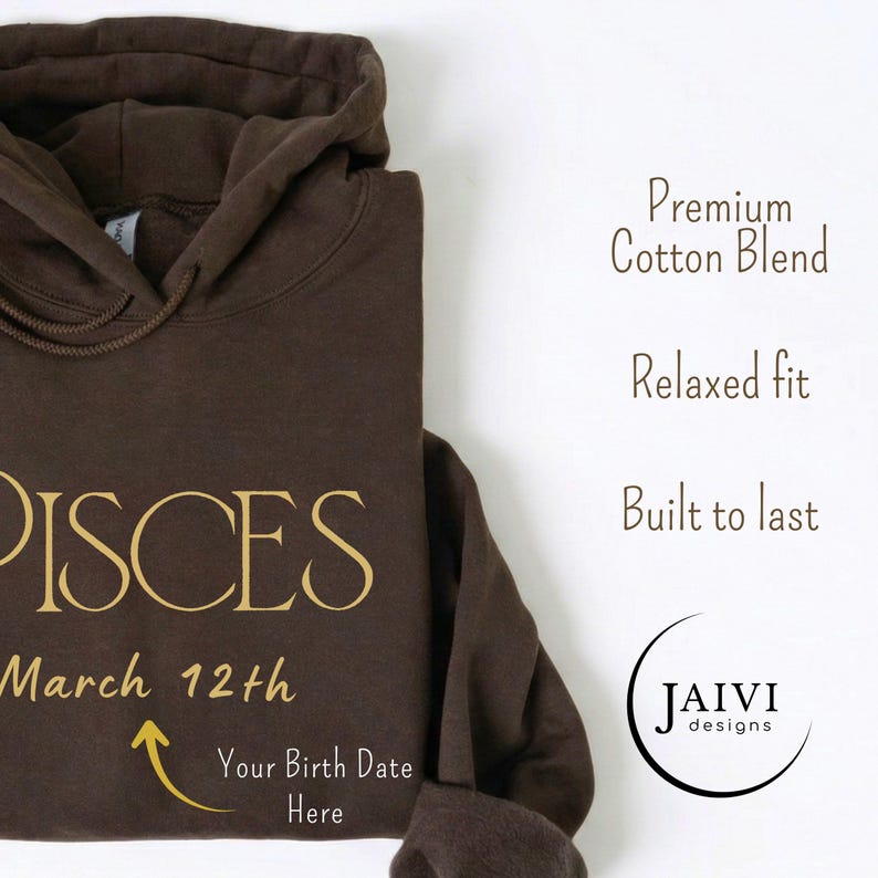 K&ouml;nnte beinhalten: Ein brauner Kapuzenpullover mit dem Wort "PISCES" in goldfarbenen Buchstaben. Darunter steht "March 12th", mit einem Pfeil, der auf "Your Birth Date Here" zeigt. Der Hoodie zeigt auch den Text "Premium Cotton Blend", "Relaxed fit" und "Built to last".
