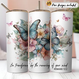 Könnte beinhalten: Weißer Becher mit goldenem Rand und Strohhalm, verziert mit einem Aquarelldesign aus Schmetterlingen und Blumen in Blau-, Rosa- und Pfirsichtönen. Der Text "Be transformed by the renewing of your mind" ist auf dem Becher aufgedruckt.