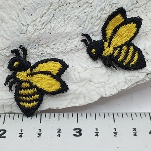 May include: Two embroidered yellow and black bee patches on a white background. The bees are about 1 1/2 inches wide.