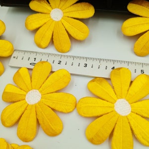 Peut inclure: Appliques de fleurs en tissu de feutre jaune avec des centres blancs. Les fleurs mesurent environ 5 cm de diamètre.