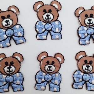 May include: Six brown teddy bear iron-on patches with blue and white checkered patterns. The bears are wearing a bow tie and have a smiling face.