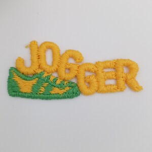May include: Yellow embroidered patch with the word "Jogger" and a green and yellow embroidered shoe.