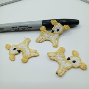 May include: Three yellow and white embroidered iron-on patches of a cartoon deer.