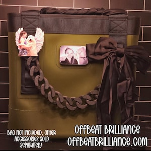 May include: Olive green tote bag with a black bow, chain, and decorative photo magnets. The bag has a black handle and trim. The text "OFFBEAT BRILLIANCE" and "OFFBEATBRILLIANCE.COM" are visible.