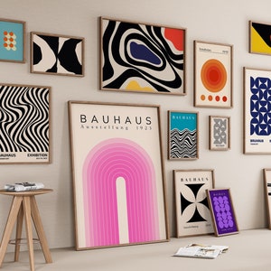 May include: A gallery wall featuring a variety of framed prints with abstract geometric designs in black, white, blue, red, yellow and pink. The prints include the text "Bauhaus Ausstellung 1923" and "Bauhaus Exhibition".