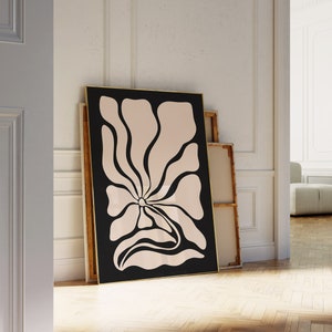 May include: A black framed print of a stylized pink flower with a black outline on a white background.