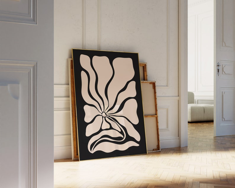 May include: A black framed print of a stylized pink flower with a black outline on a white background.