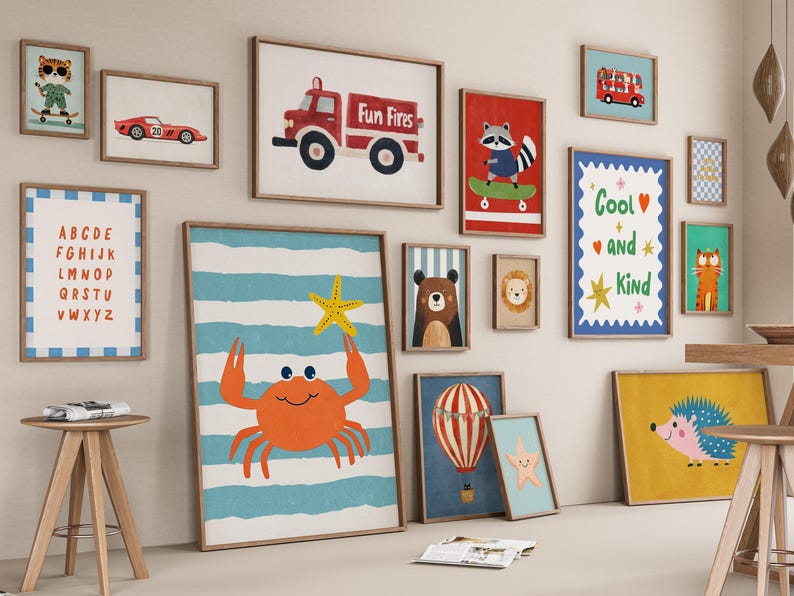 May include: A collection of framed art prints featuring various illustrations. The prints include a red fire truck, a crab holding a starfish, a raccoon on a skateboard, and an alphabet chart. The color palette includes red, blue, yellow, and brown.