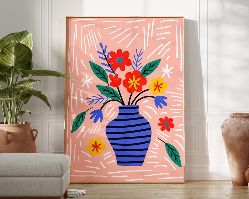 Puede incluir: Un jarr&oacute;n azul y blanco a rayas con un ramo de flores de colores. Las flores son rojas, amarillas, naranjas y azules. El jarr&oacute;n est&aacute; sobre un fondo rosa con l&iacute;neas blancas.