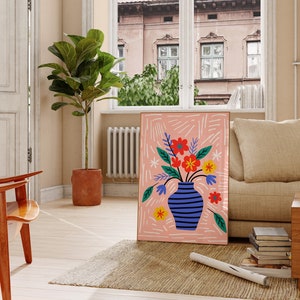 Puede incluir: Un fondo abstracto rosa y blanco con un jarr&oacute;n de rayas azules y blancas lleno de flores de colores. El jarr&oacute;n est&aacute; sobre un fondo rosa con l&iacute;neas blancas.