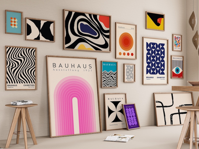 May include: A gallery wall featuring a variety of framed prints with abstract geometric designs in black, white, blue, red, yellow and pink. The prints include the text "Bauhaus Ausstellung 1923" and "Bauhaus Exhibition".