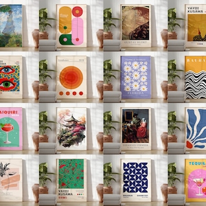 Pode incluir: Uma colagem de 12 impress&otilde;es de arte diferentes que apresentam v&aacute;rios estilos e temas, incluindo designs abstratos, geom&eacute;tricos, florais e figurativos. As impress&otilde;es s&atilde;o exibidas em um formato de grade em uma parede branca com plantas em vasos na frente delas.