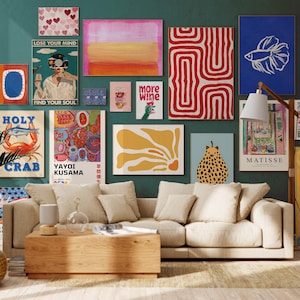 May include: A teal wall adorned with framed art prints, including abstract designs, a crab illustration, and a betta fish. The prints feature text such as "LOSE YOUR MIND FIND YOUR SOUL". A beige sofa and wooden coffee table are in front of the wall.