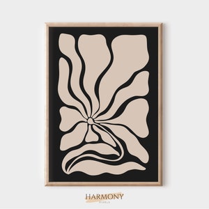May include: Abstract art print featuring a beige flower with black outlines on a black background. The print is framed in a light wood frame.