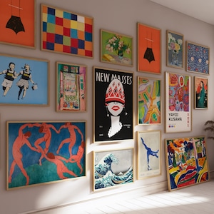 May include: A collection of framed art prints displayed on a wall. The artwork includes various styles, such as abstract, figurative, and graphic designs. The frames are a light brown color, and the art pieces are of different sizes and shapes.