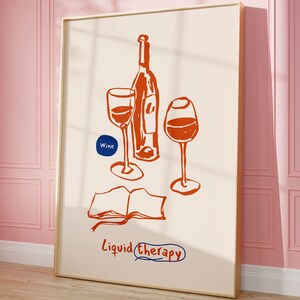 May include: A framed illustration of two wine glasses and a bottle of wine with the text "Liquid Therapy" and "Wine" in a blue circle. The illustration is in orange on a cream background.