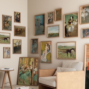 May include: A wall gallery featuring framed artwork of dancers, horses, and landscapes. The gallery is decorated with a variety of styles and colors, including black and white, sepia tones, and vibrant hues. The artwork is displayed on a white wall with a light brown wooden floor.