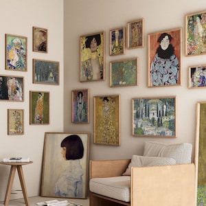 May include: A gallery wall with various framed art prints, including portraits, landscapes, and abstract designs. The prints are arranged in a grid pattern on a white wall. The wall is painted a light beige color.