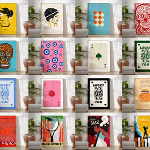 Pode incluir: Uma cole&ccedil;&atilde;o de 12 impress&otilde;es coloridas emolduradas com v&aacute;rios designs, incluindo uma caveira, um cart&atilde;o de jogo, um padr&atilde;o geom&eacute;trico e um rosto de mulher. As impress&otilde;es est&atilde;o dispostas em uma grade em uma parede branca.