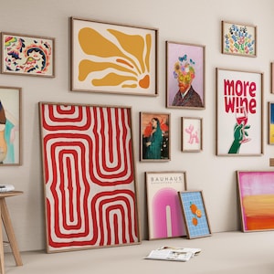May include: A collection of framed art prints in various sizes and styles, including abstract designs, floral patterns, and portraits. The color palette includes red, yellow, blue, and pink, with wooden frames.