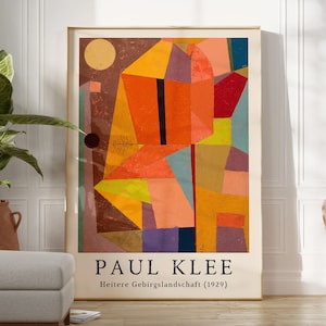 Pode incluir: Impressão de arte abstrata com formas geométricas em tons de laranja, amarelo, vermelho e marrom. A impressão é intitulada "Heitere Gebirgslandschaft (1929)" e assinada por "Paul Klee".