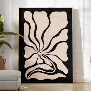 May include: A black and white abstract art print featuring a large, stylized flower with a light pink center. The flower is outlined in black and has a flowing, organic shape.