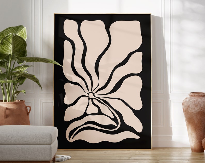May include: A black and white abstract art print featuring a large, stylized flower with a light pink center. The flower is outlined in black and has a flowing, organic shape.