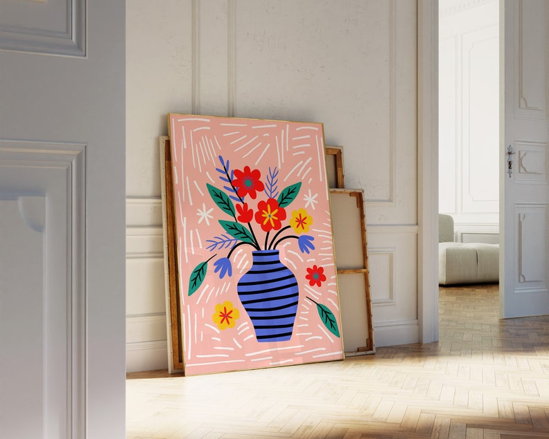 Puede incluir: Un fondo abstracto rosa y blanco con un jarr&oacute;n azul y blanco a rayas lleno de flores coloridas. Las flores son rojas, amarillas y naranjas. El jarr&oacute;n est&aacute; sobre una superficie blanca.