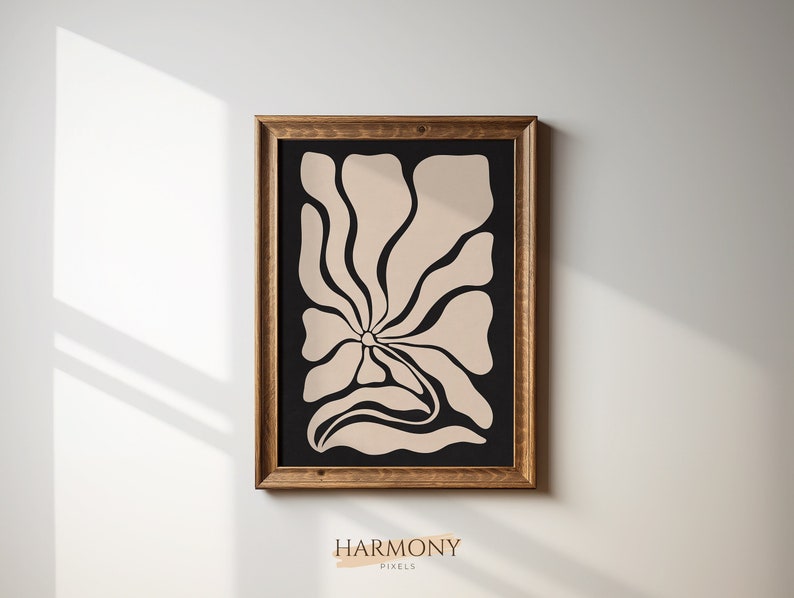 May include: A framed print with a beige abstract floral design on a black background. The frame is brown wood.