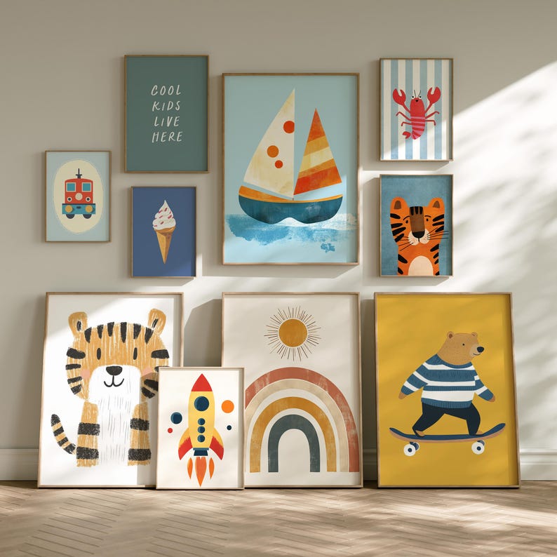 May include: A collection of framed art prints featuring whimsical illustrations. The prints include a sailboat, tiger, bear on a skateboard, rocket, rainbow, and a lobster. One print reads "COOL KIDS LIVE HERE". The artwork is in a colorful, playful style.