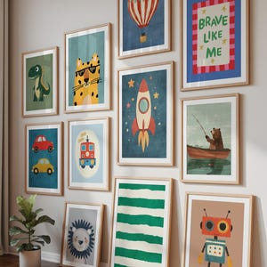 May include: A collection of framed art prints with a children's theme. The prints feature illustrations of a dinosaur, a tiger wearing sunglasses, a hot air balloon, a rocket, a bear fishing, cars, a train, a lion, a robot, and the text "BRAVE LIKE ME".