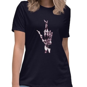 May include: A navy blue t-shirt with a pink skeleton hand making a peace sign.