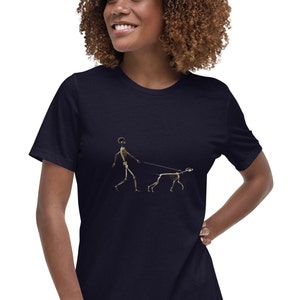 May include: A navy blue t-shirt with a gold skeleton graphic of a person walking a dog.