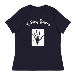 May include: Navy blue t-shirt with white text that reads "X-Ray Queen" and a white silhouette of a hand x-ray.