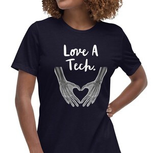 May include: A navy blue t-shirt with a white graphic of two hands forming a heart shape. The hands are x-ray images of bones. The text "Love A Tech." is above the hands.