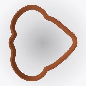 May include: A brown cookie cutter with an irregular, rounded triangular shape. The frame is solid and continuous, featuring smooth, curved edges that form a distinct, asymmetrical outline. The object is presented against a plain, neutral background.