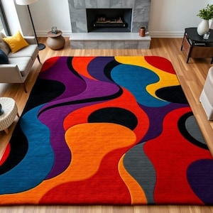 May include: A rectangular area rug with a vibrant, abstract design. The rug features flowing, organic shapes in shades of red, orange, yellow, blue, purple, black, and gray. The rug is placed on a hardwood floor.
