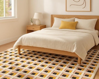 May include: A bedroom scene featuring a wooden bed frame with cream-colored bedding and a mustard-yellow accent pillow. A geometric rug with a repeating pattern of black, yellow, and pink squares covers the floor. A framed abstract art piece hangs on the wall.