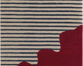 May include: A rectangular rug with a distinctive design. The upper part has navy blue horizontal stripes on a beige backdrop. The lower section is a solid burgundy colour with an organic, flowing shape.