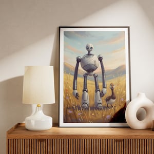 Op de afbeelding: Een ingelijste muurkunstprint met een lange, rondborstige witte robot die in een goudkleurig grasveld naast een kleine bruine eend staat. De achtergrond toont glooiende heuvels onder een zachte, lichtblauwe en oranje lucht, digitale illustratie.