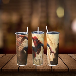 May include: Three stainless steel tumblers with lids and straws. Each tumbler features a different image of Spider-Man swinging through a city. The background is a yellow-brown color with a brick wall.
