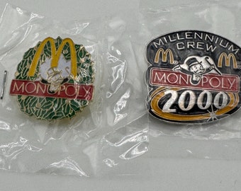 Two (2) McDonald's Monopoly Employee Pins 2000 Millenium Crew Pin and 1995 Christmas Holly Pin